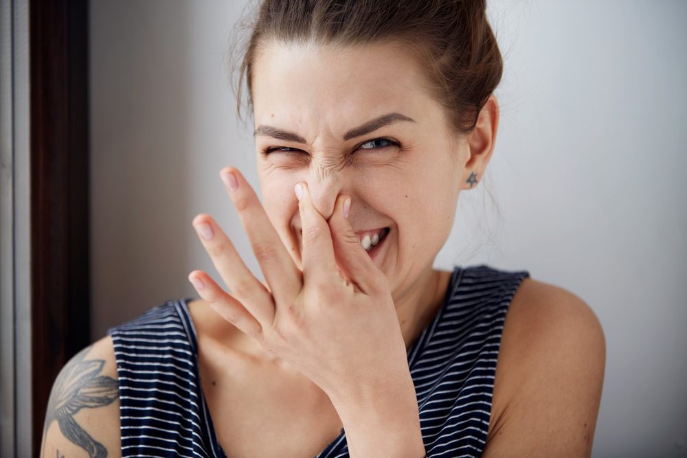 Female gesture smells bad. Headshot woman pinches nose with fingers hands looks with disgust something stinks bad smell situation. Human face expression body language reaction