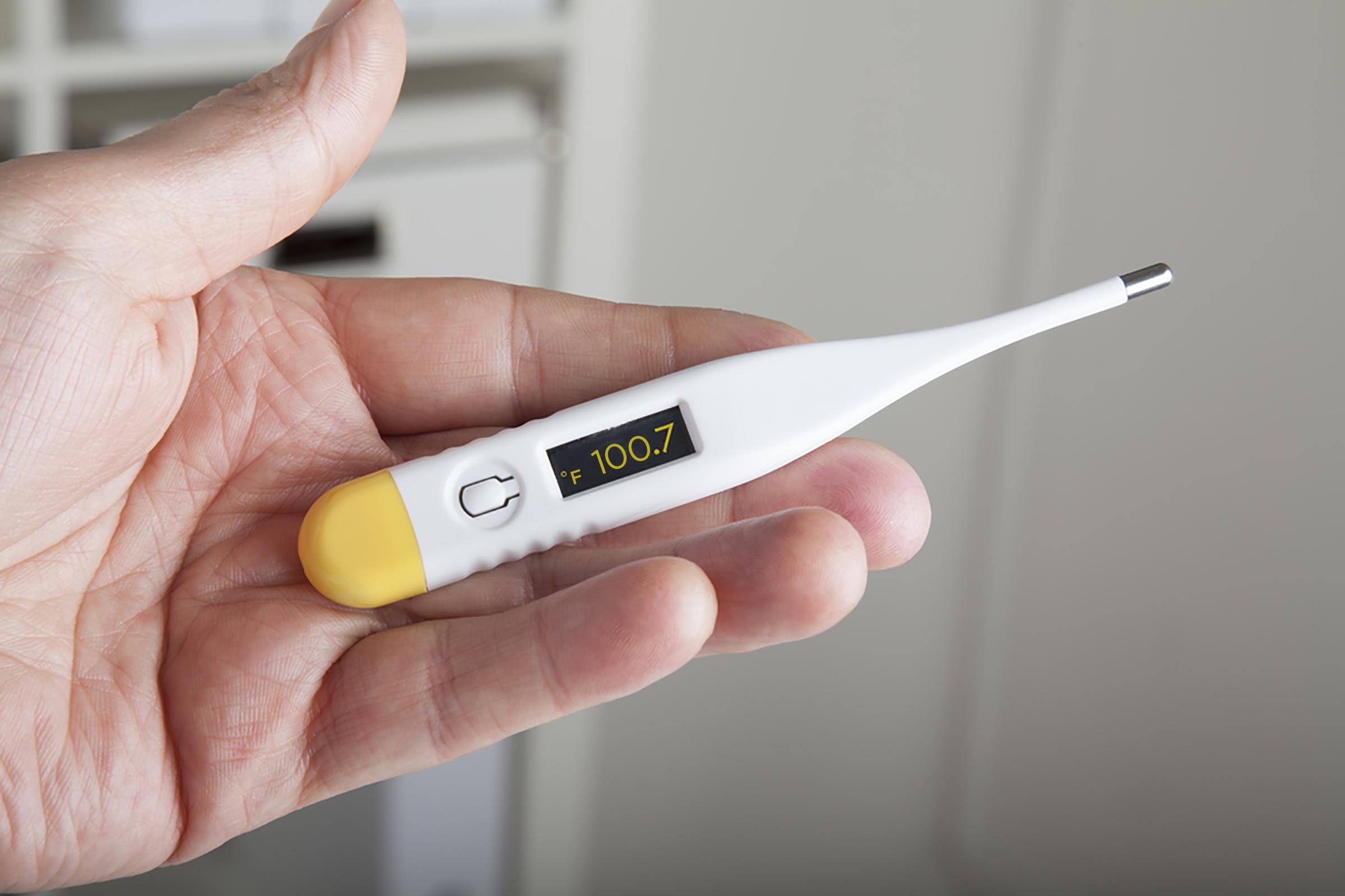 clinical thermometer in the left hand of a physician showing high fever