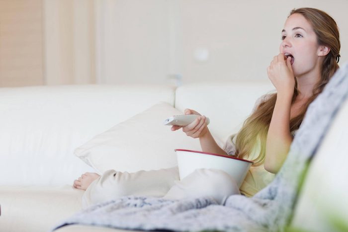 Woman having popcorn while enjoying a movie