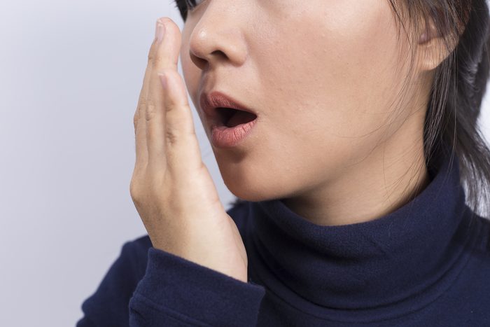 Woman checking her breath with her hand