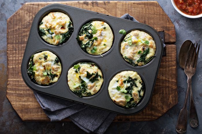 High protein egg muffins with kale and ground turkey in a muffin tin overhead shot