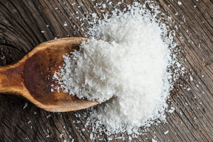 Grounded coconut flakes with wooden spoon