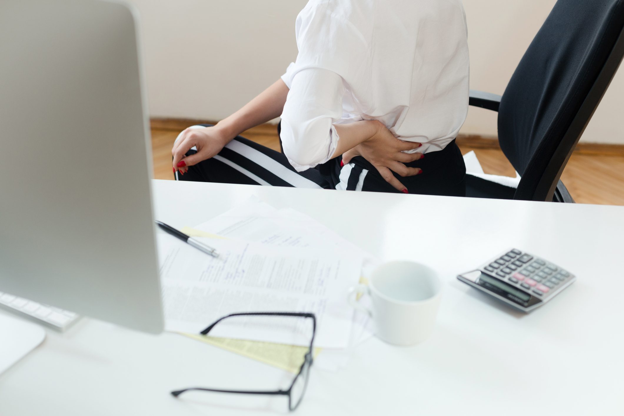 woman with back pain sitting at desk