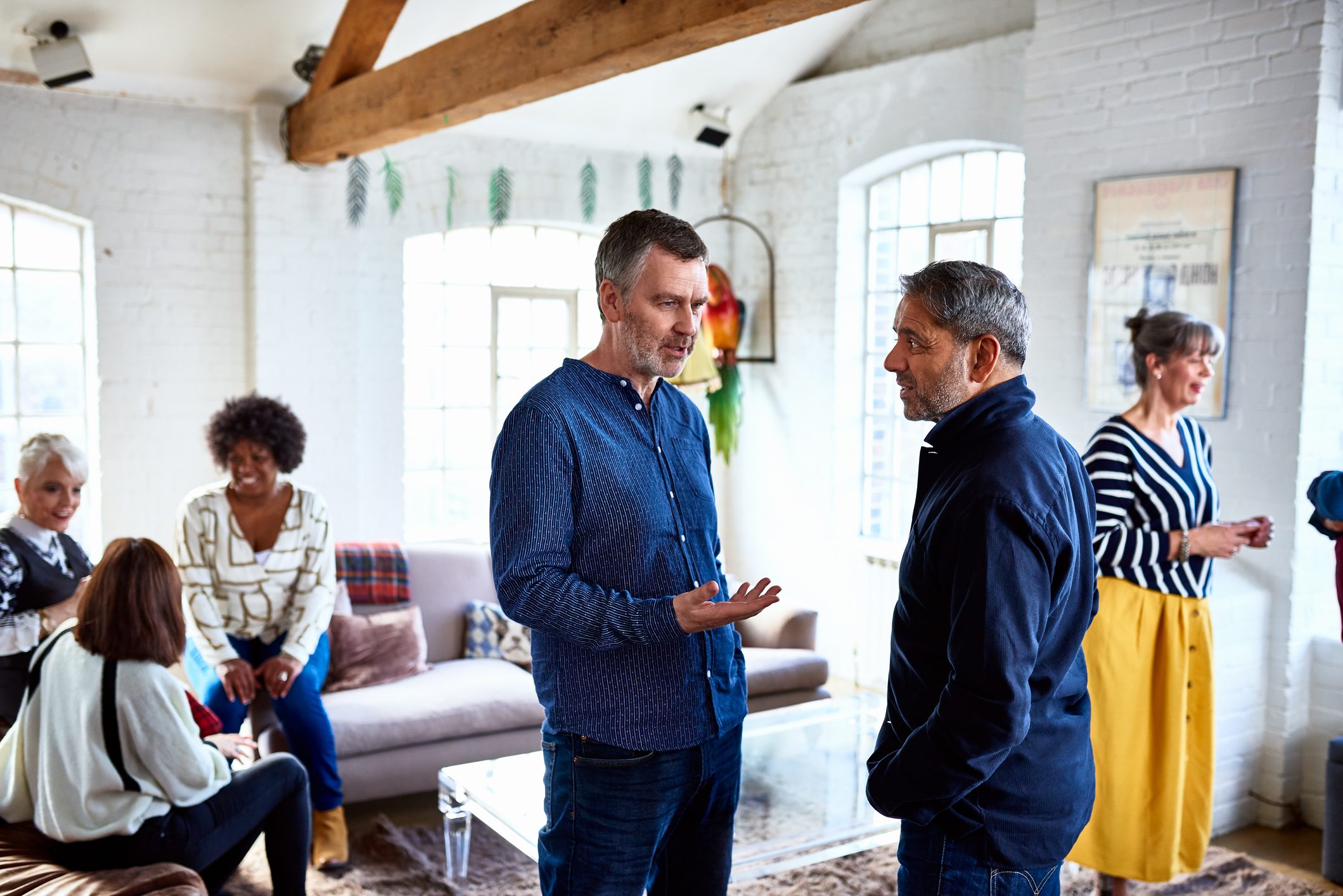 two mature men talking at a family gathering