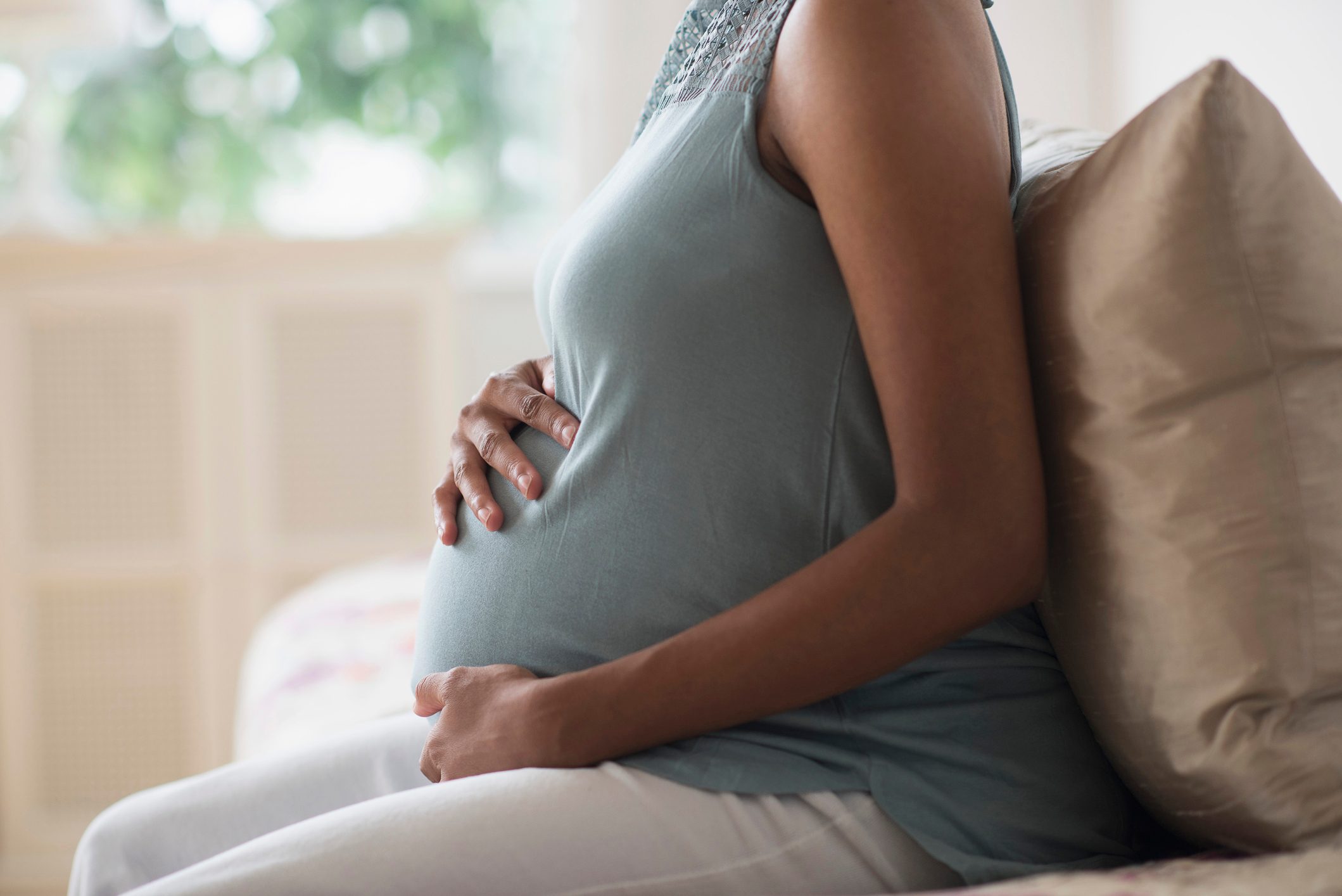 close up shot of pregnant woman holding her stomach