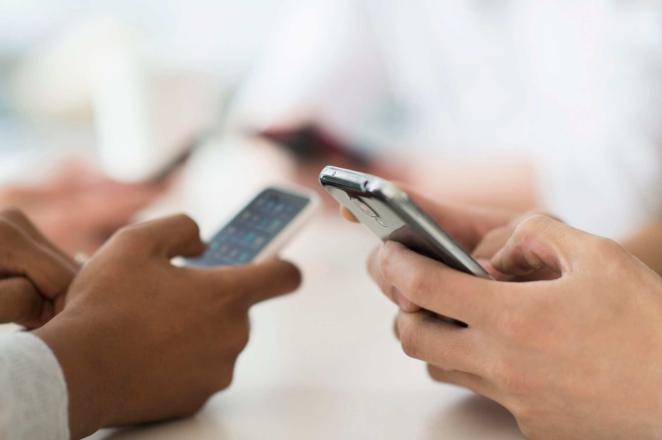 close up of friends using smartphones