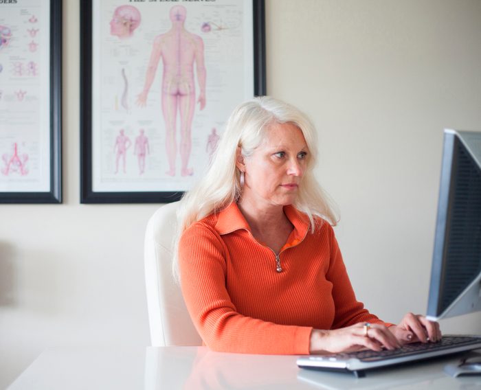 chiropractor working at desk computer