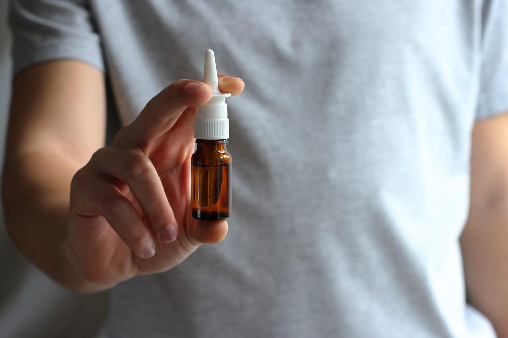Nasal spray in male hands.