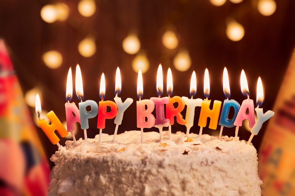 Birthday cake with candles, bright lights bokeh.Celebration.