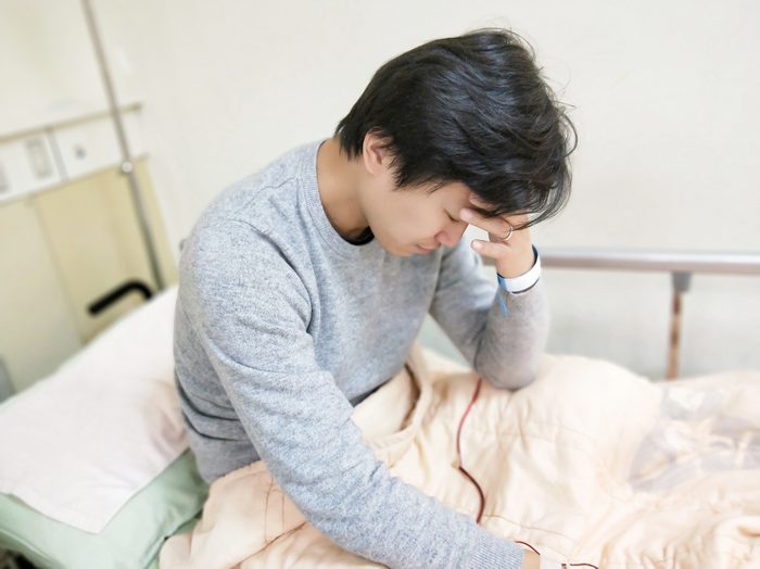 patient man with headache on the hospital bed