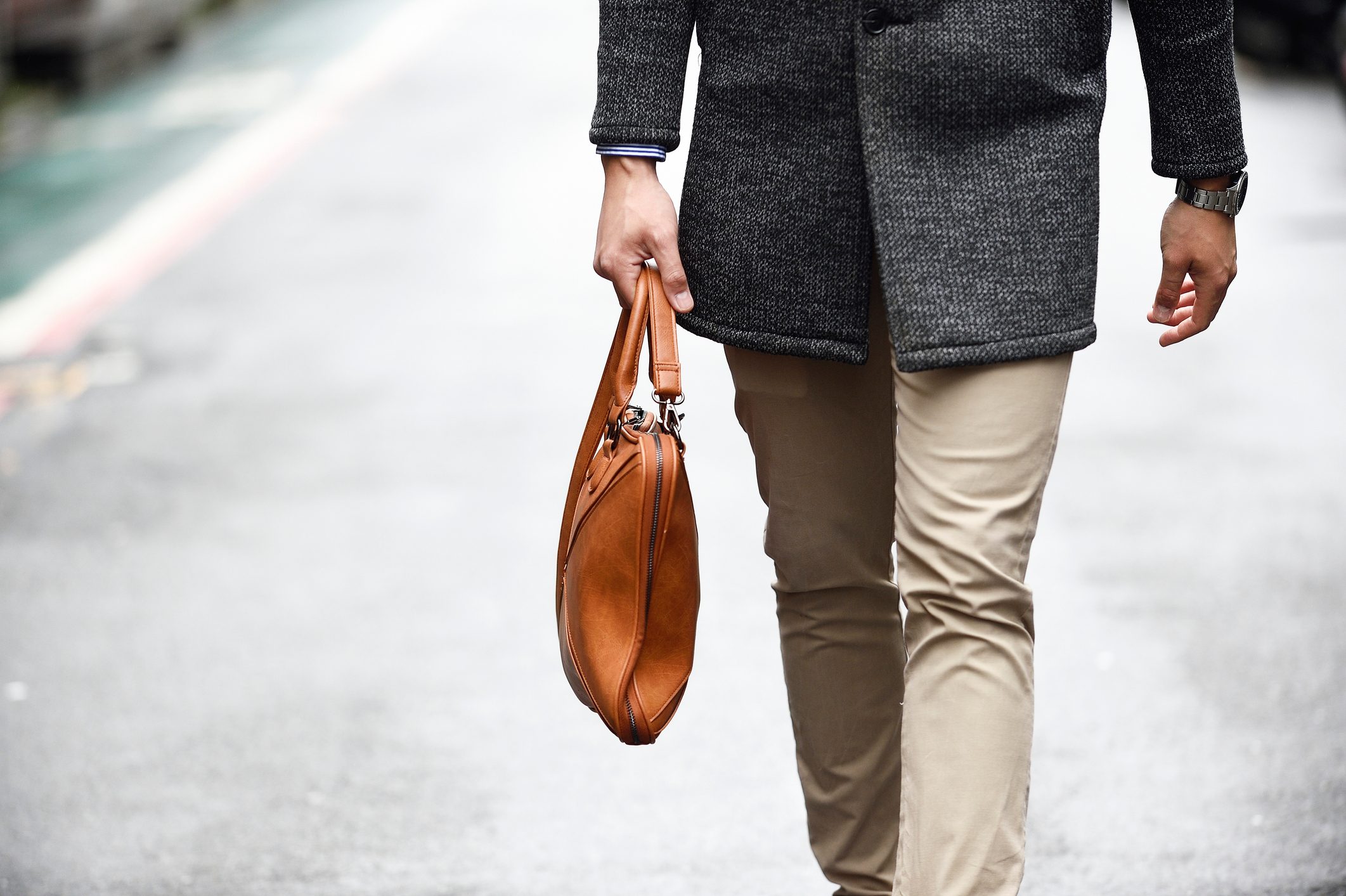 cropped shot of man holding man purse