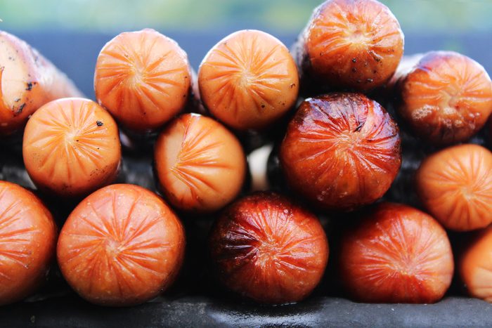 Fresh Greasy Hot Dogs Piled on Grill for Holiday Weekend Party