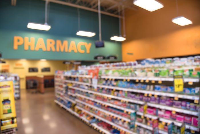 Blurred abstract background inside pharmacy store with arranged variation of pharmaceutical and medical supplies product in label on shelves display. Indoor space of drug store with blurred medicines.