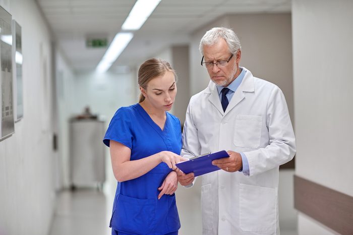 senior doctor and young nurse with tablet pc computer at hospital hospital ward