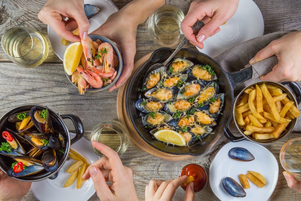 Family having summer lunch with seafood, top view