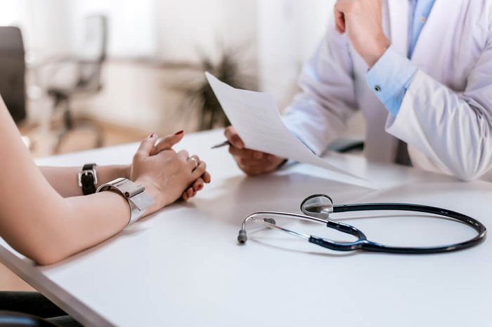 Doctor speaking with a woman patient, stethoscope on table