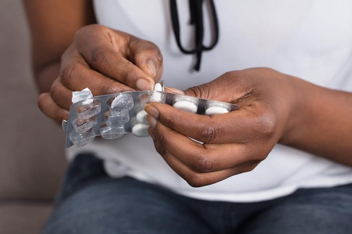 Hands taking a pill out of a blister pack