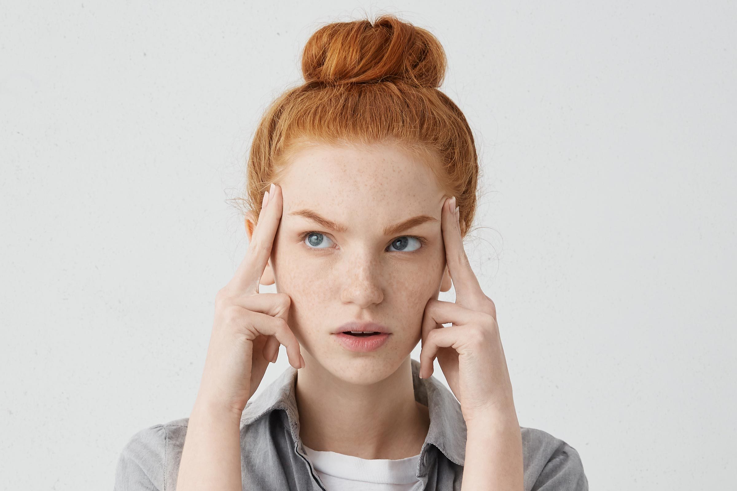 woman holding her temples