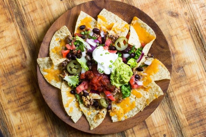 Homemade Nachos with chips salsa guacamole and cheese, overhead view