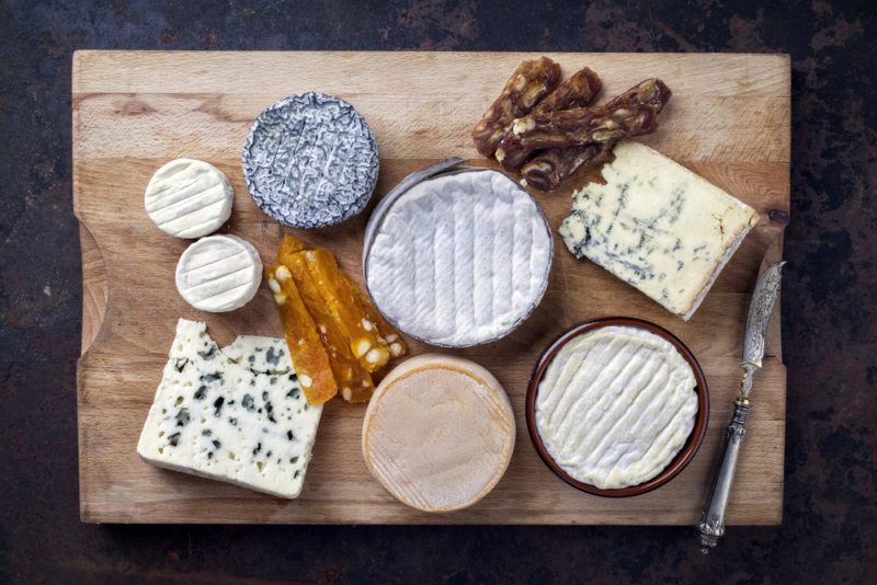 French Cheese Platter with Spanish Dulce de Membrillo as top view on a wooden board 