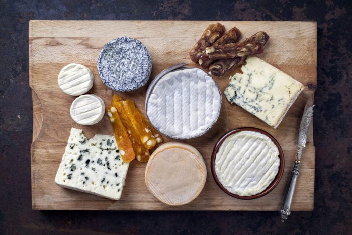 French Cheese Platter with Spanish Dulce de Membrillo as top view on a wooden board