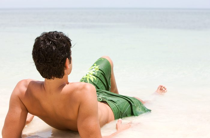 man lying in surf at the beach