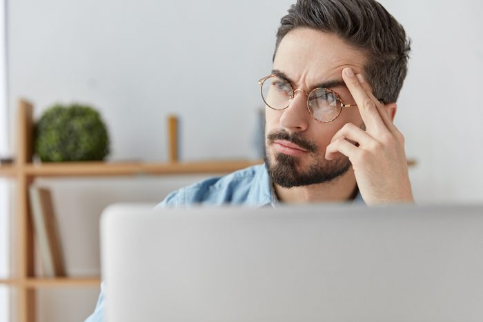 man thinking at his computer