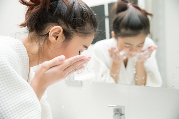 woman washing her face