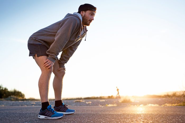 Portrait of young man resting after running in the street.