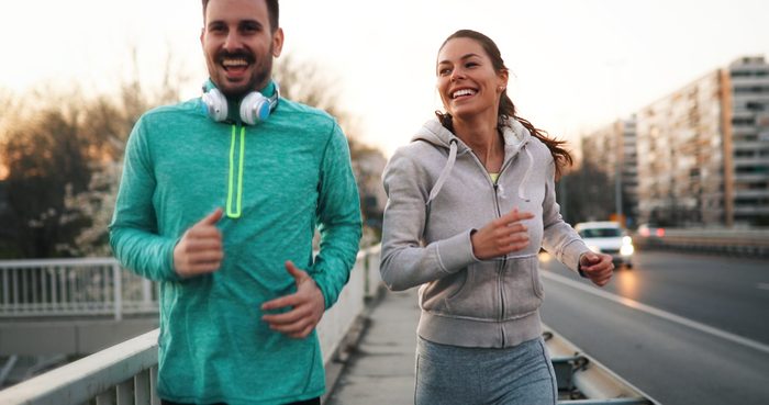 Man and woman running outside on sunny day