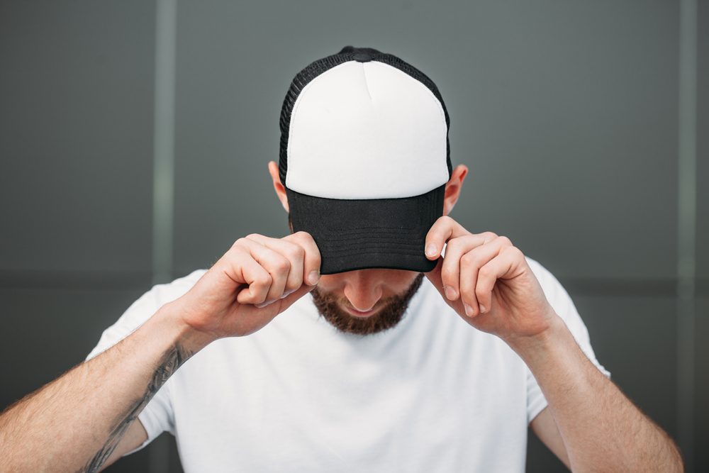 Man wearing black and white baseball hat