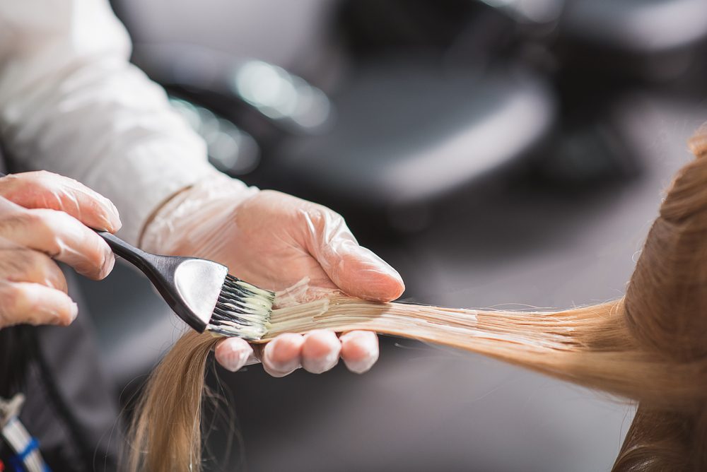 Man in gloves is dying hair