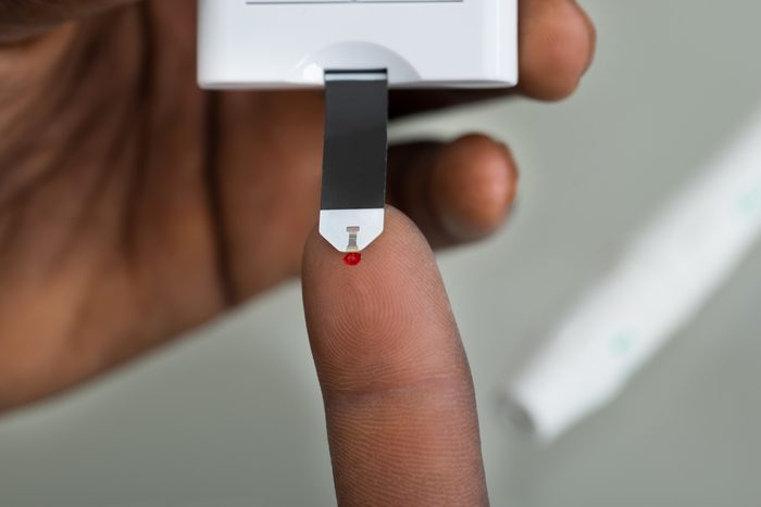 Close-up Of Patient Hands Measuring Glucose Level Blood Test With Glucometer