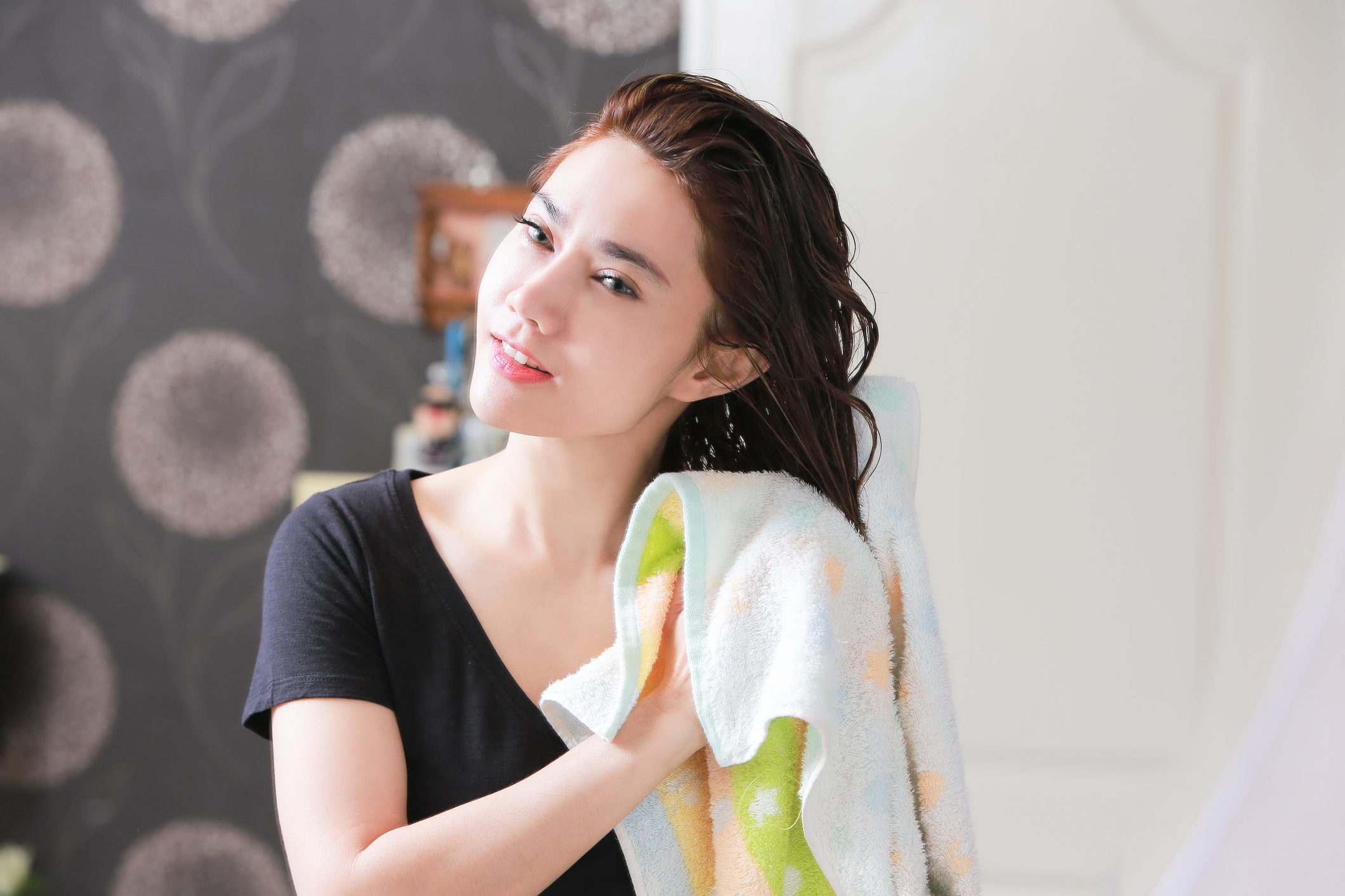 woman drying hair with towel