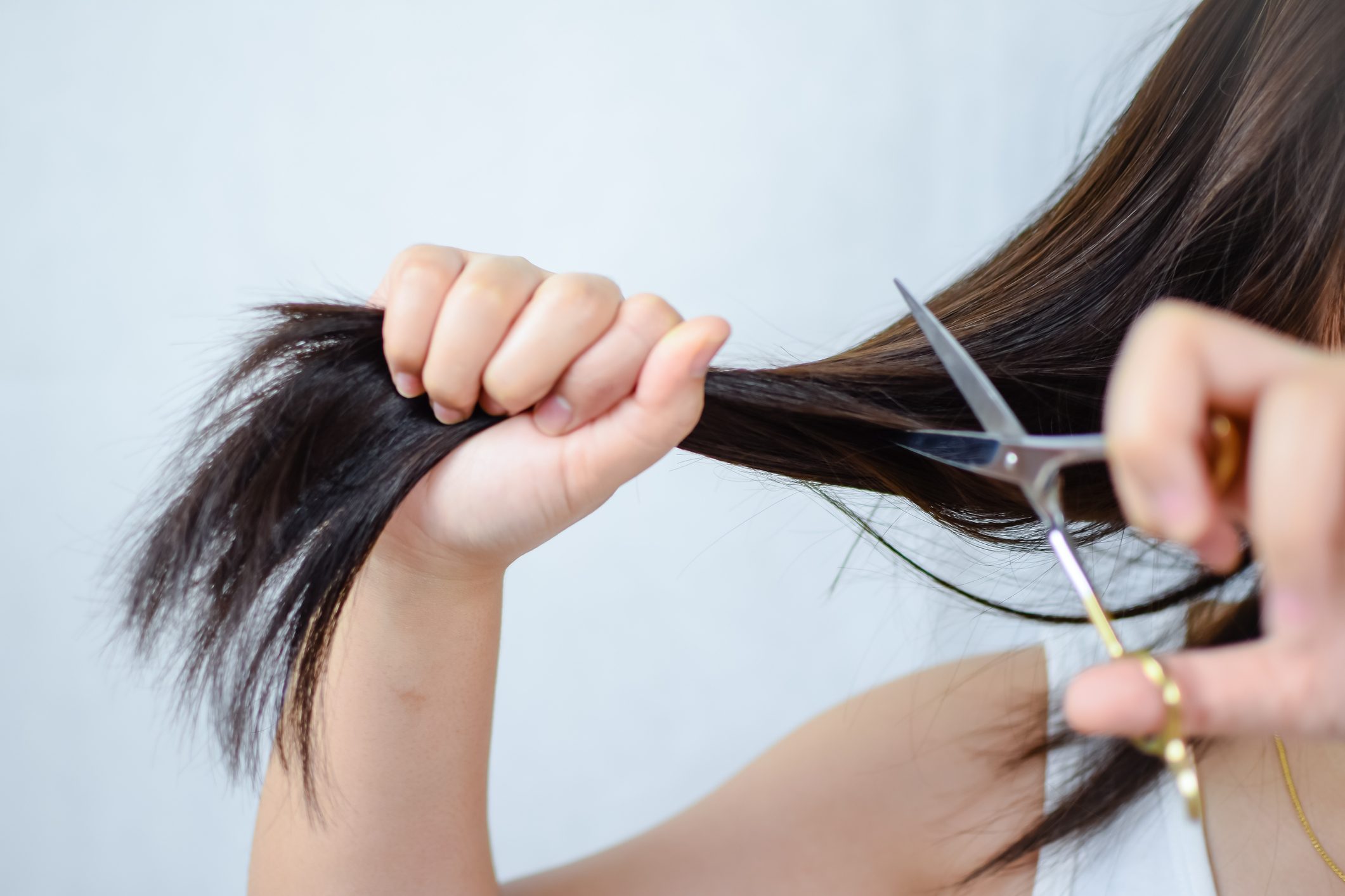 woman cutting her own hair close up cropped shot