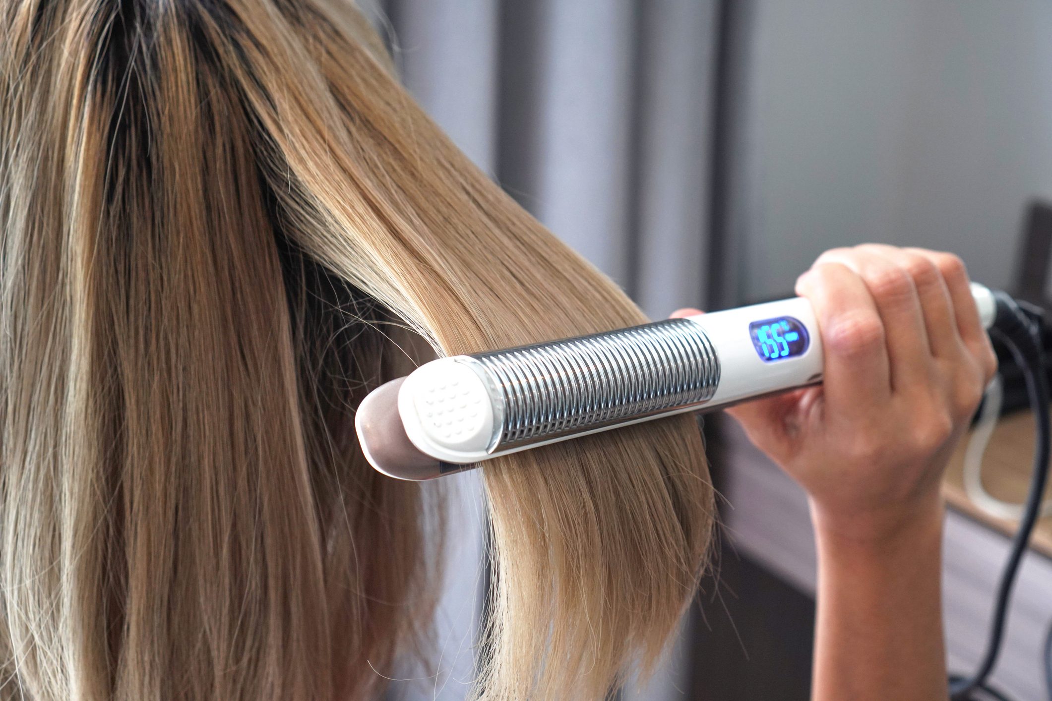 woman straightening hair