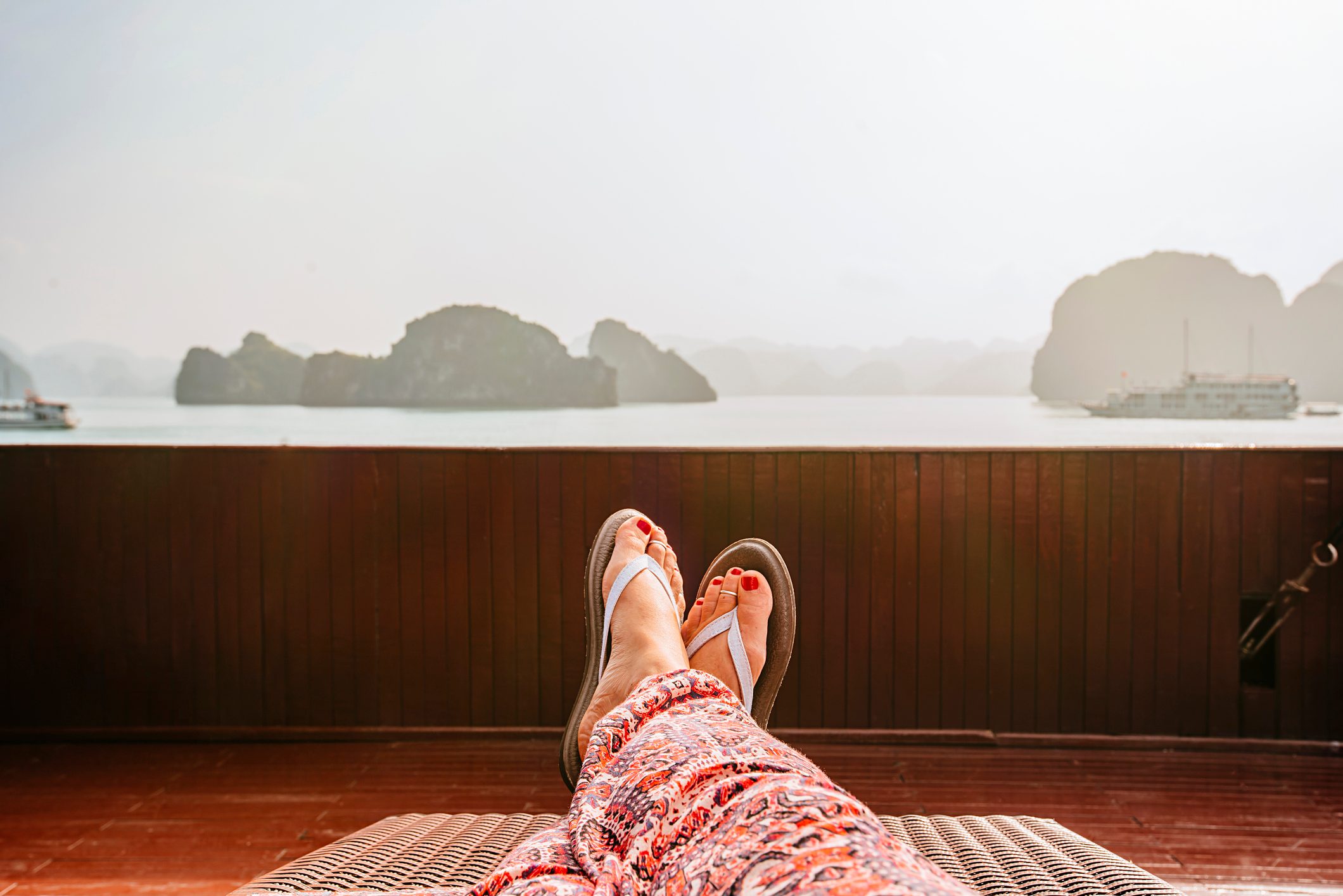 view of woman's legs laying outside wearing flip flops