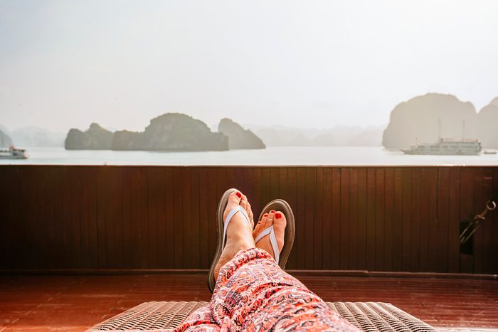 view of woman's legs laying outside wearing flip flops