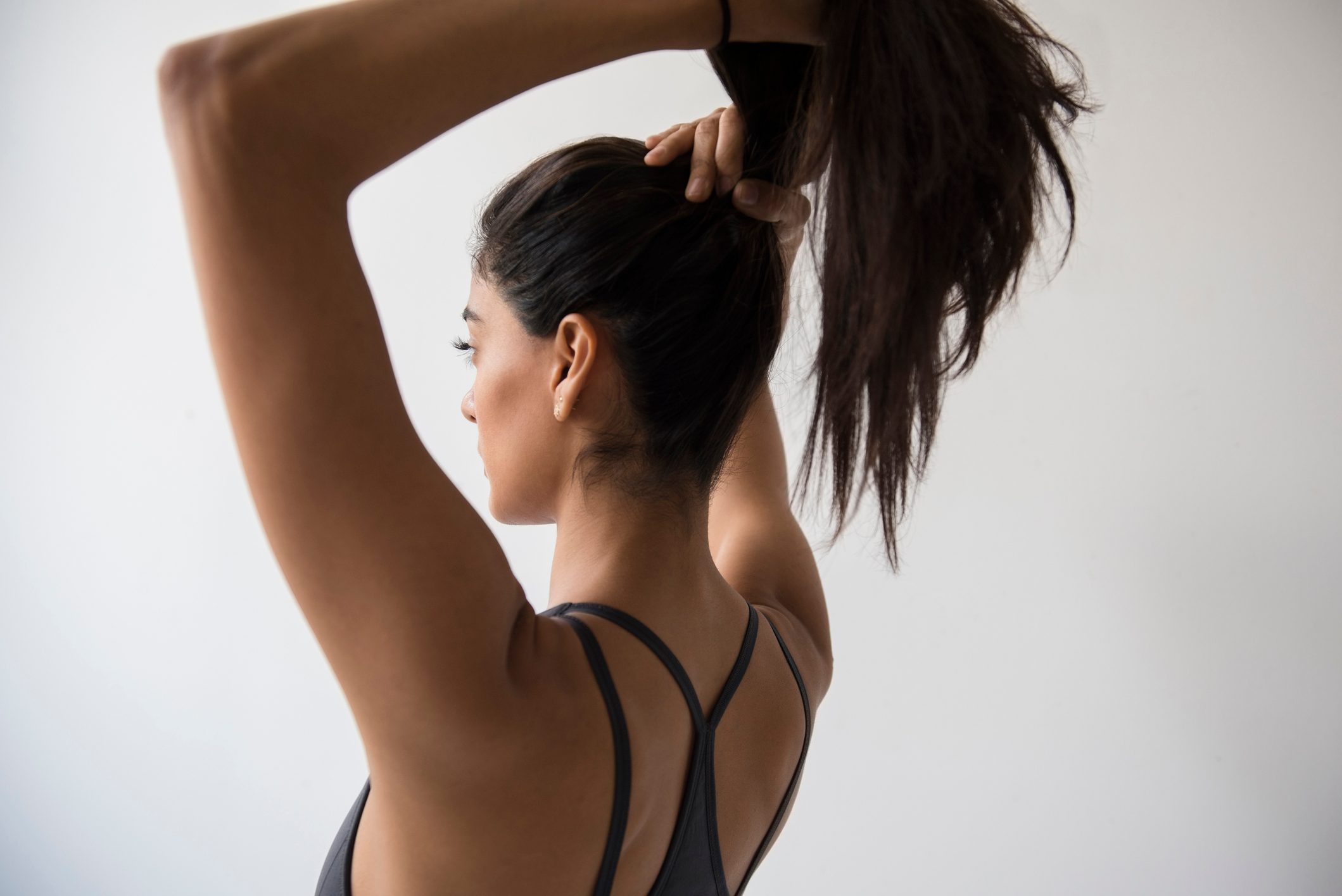 woman putting her hair into ponytail