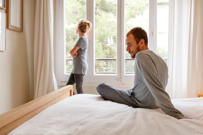 mid adult couple in bedroom having an argument