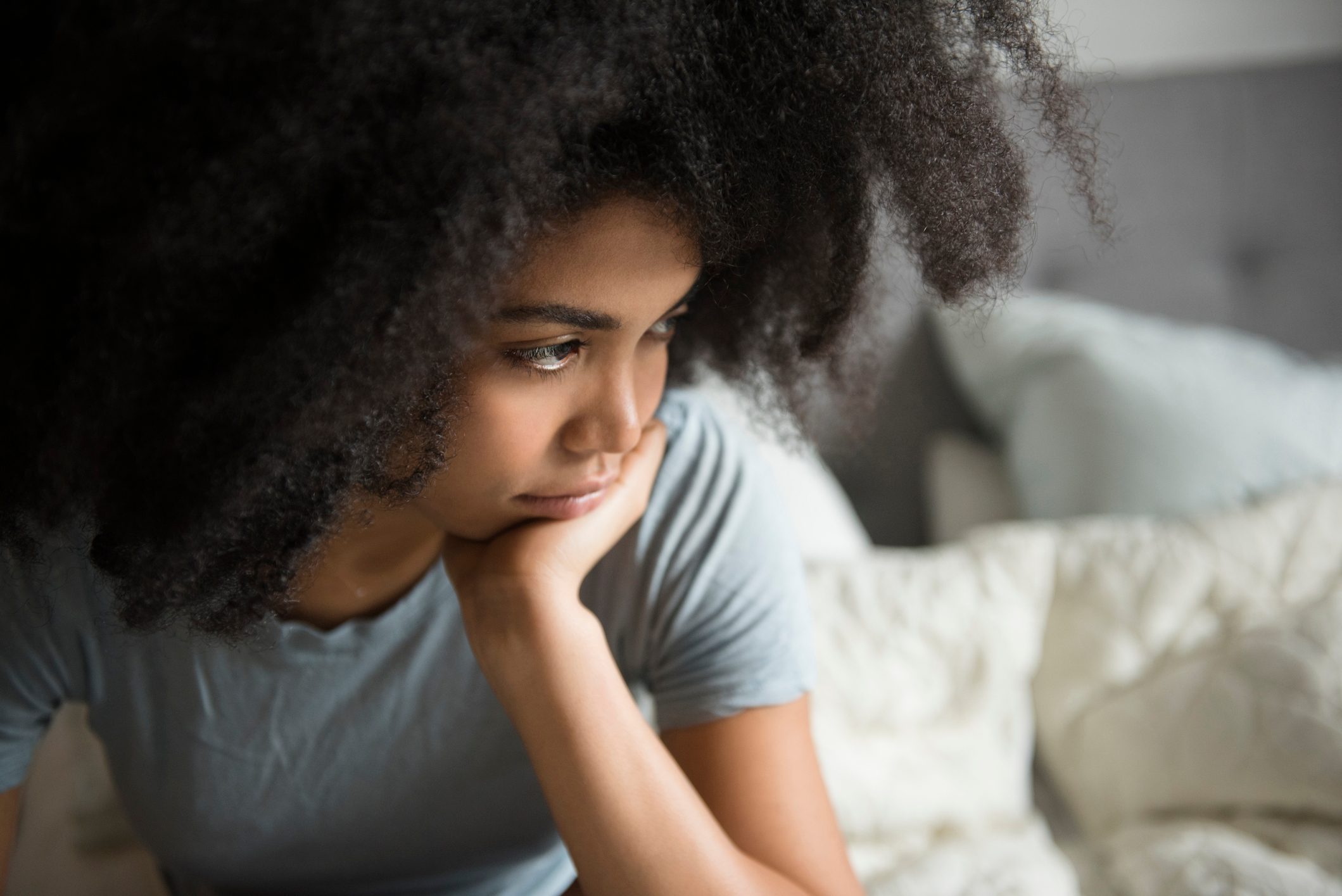 stressed depressed young woman with chin in her palm