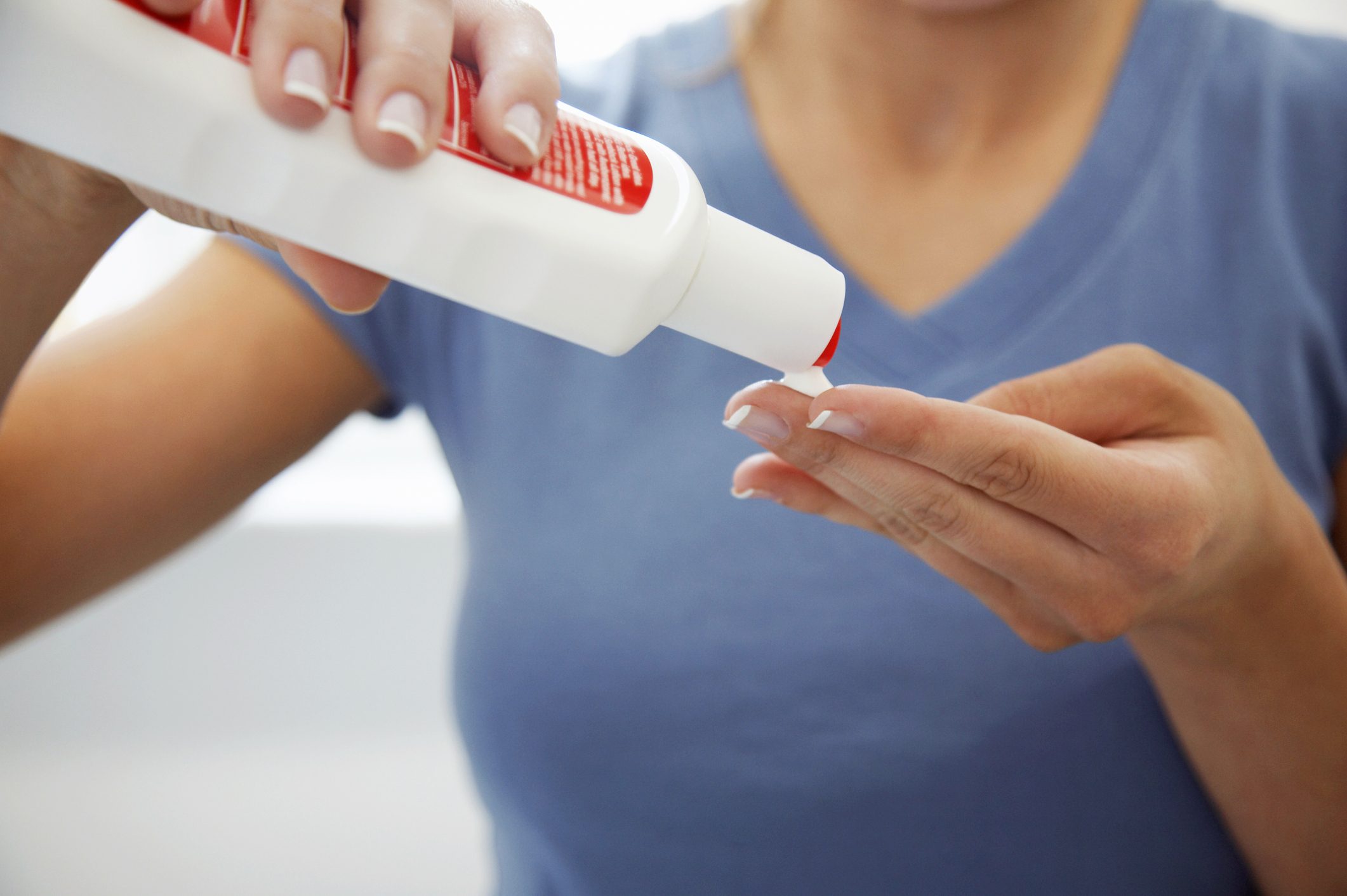 close up of woman squeezing sunscreen onto hand
