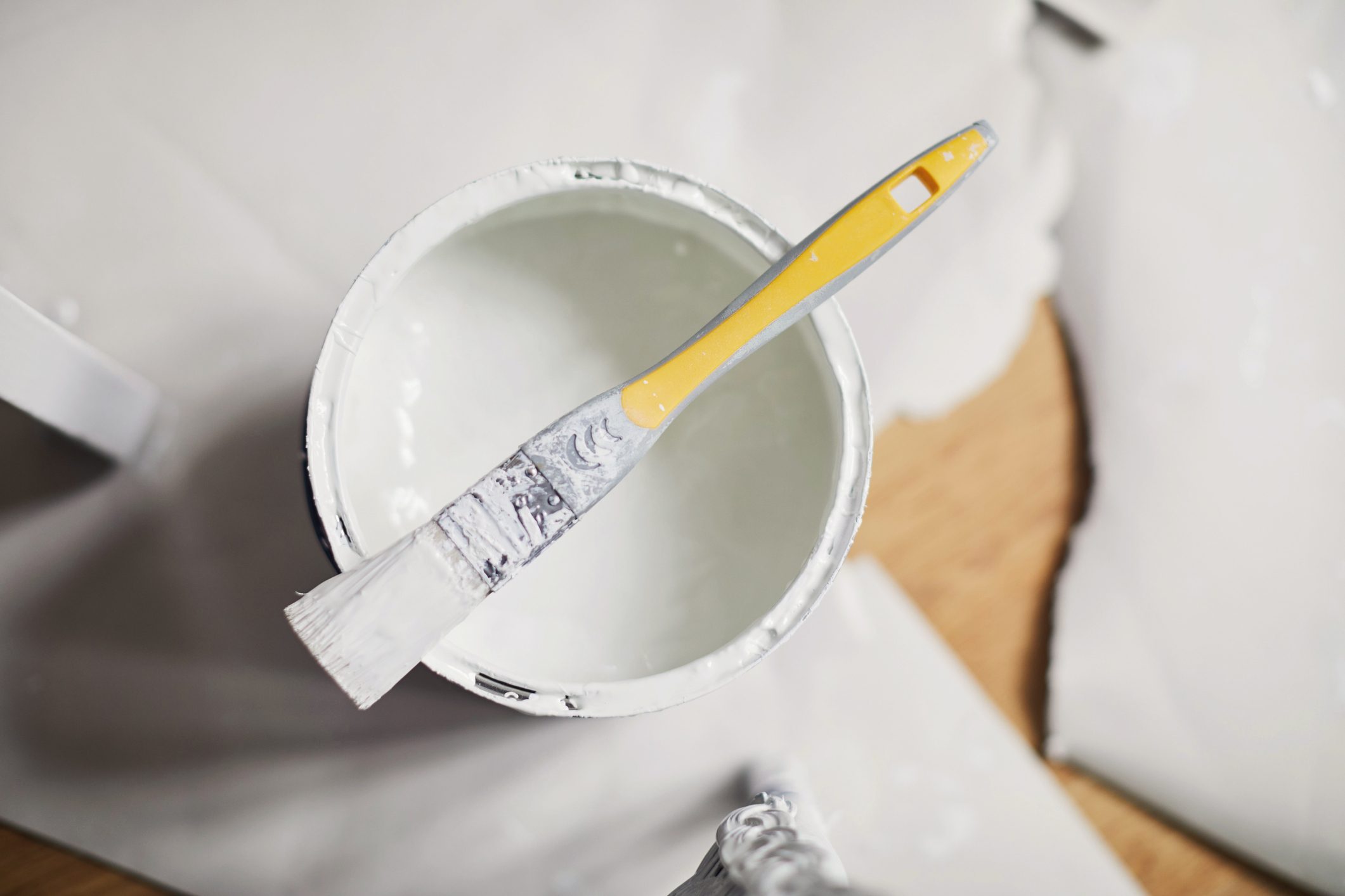 overhead shot of open paint bucket with paintbrush