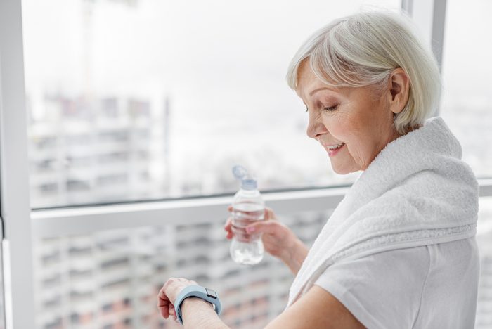Senior woman using smartwatch after training