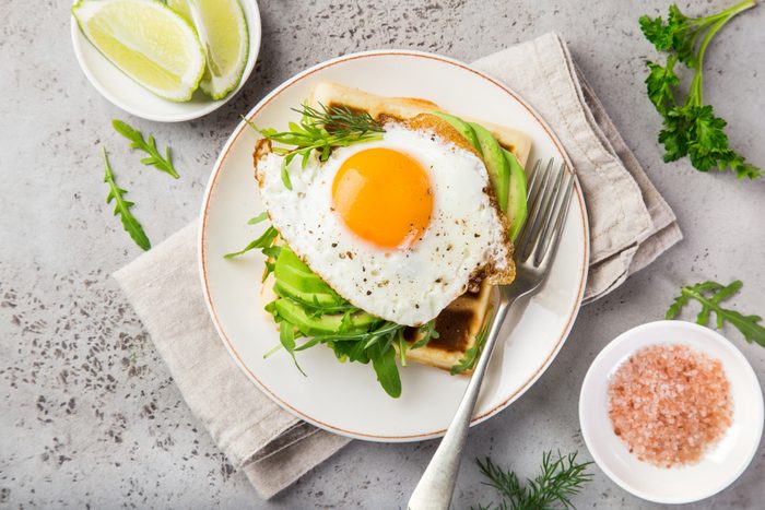 savory waffles with avocado, arugula and fried egg