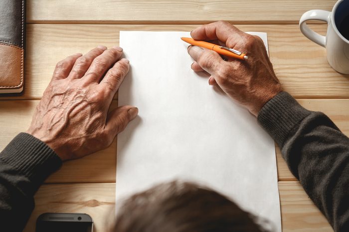 The old man wrote a testament, sitting at a wooden table