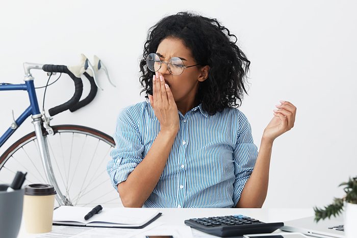 woman yawning at her desk