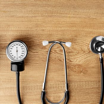 Medical manometer and a stethoscope on wooden background