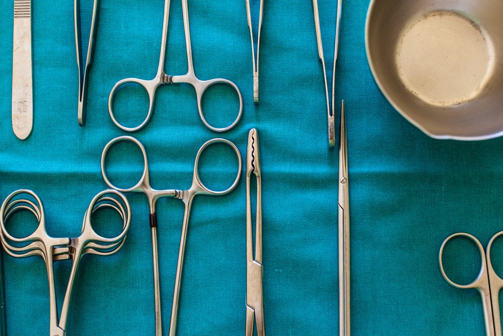 surgical instruments and tools including scalpels, forceps and tweezers arranged on a table for a surgery