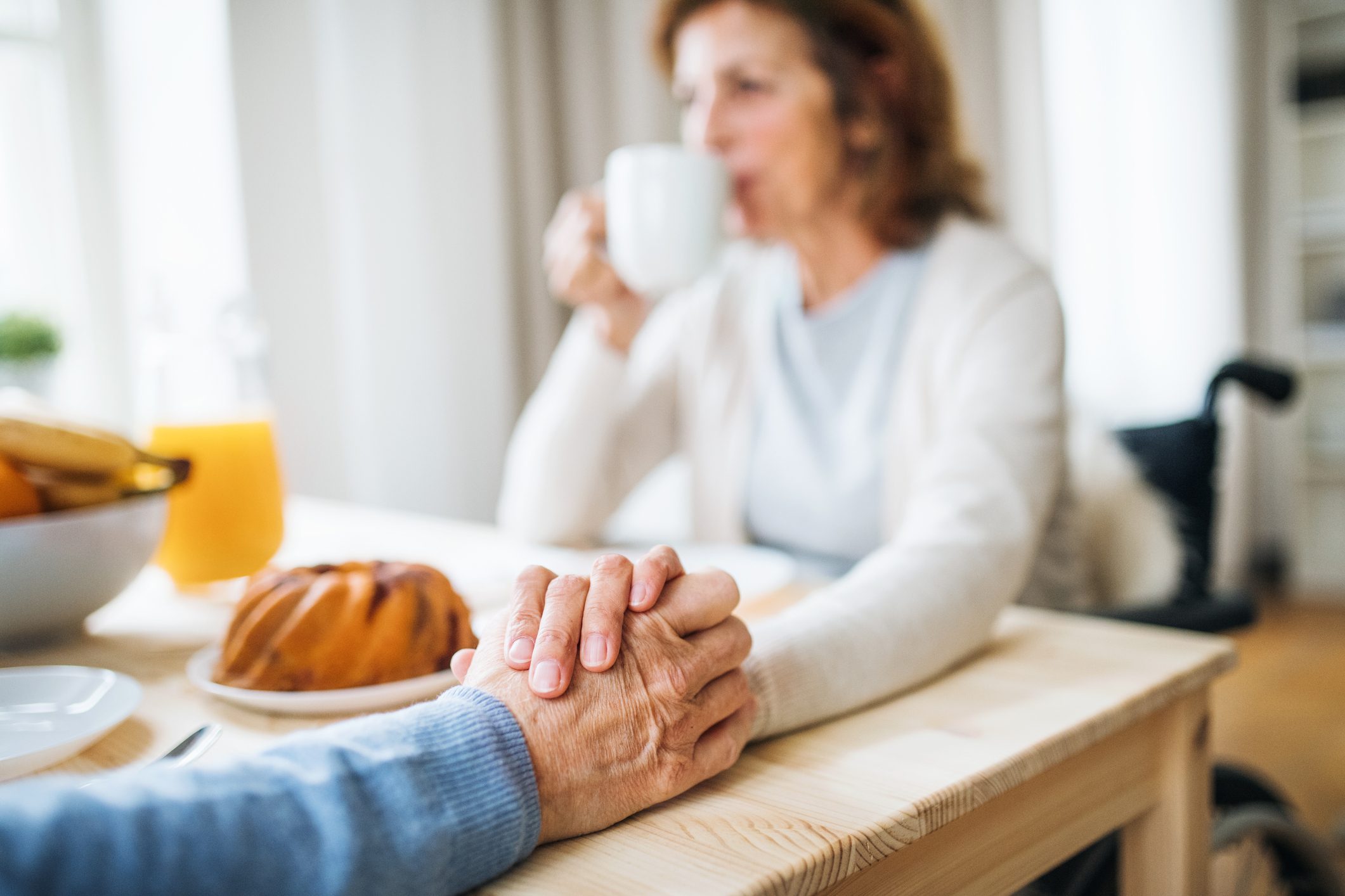 close up of couple holding hands at table